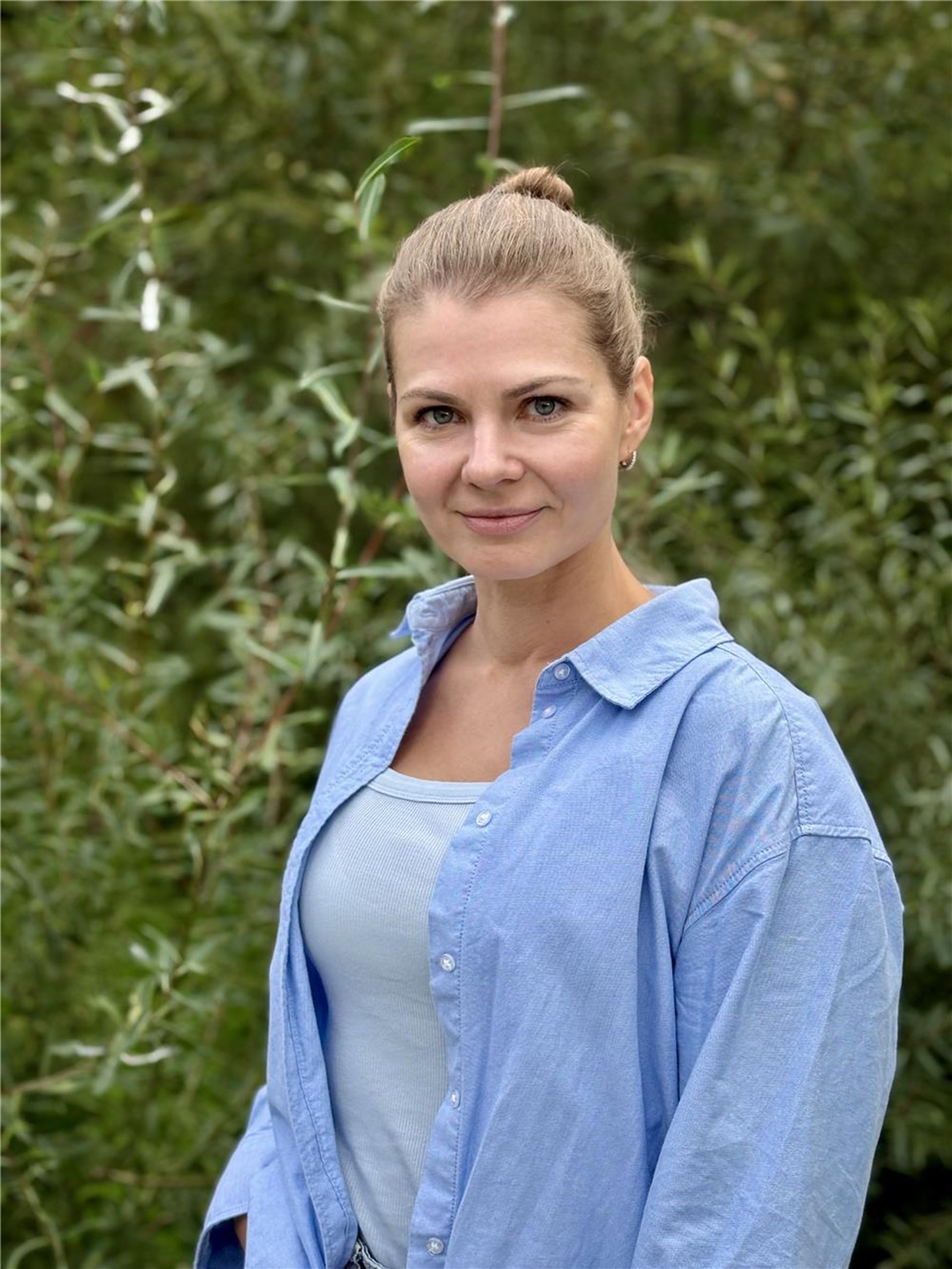 Eine Frau mit blonden geschlossenen Haaren ist zu sehen.